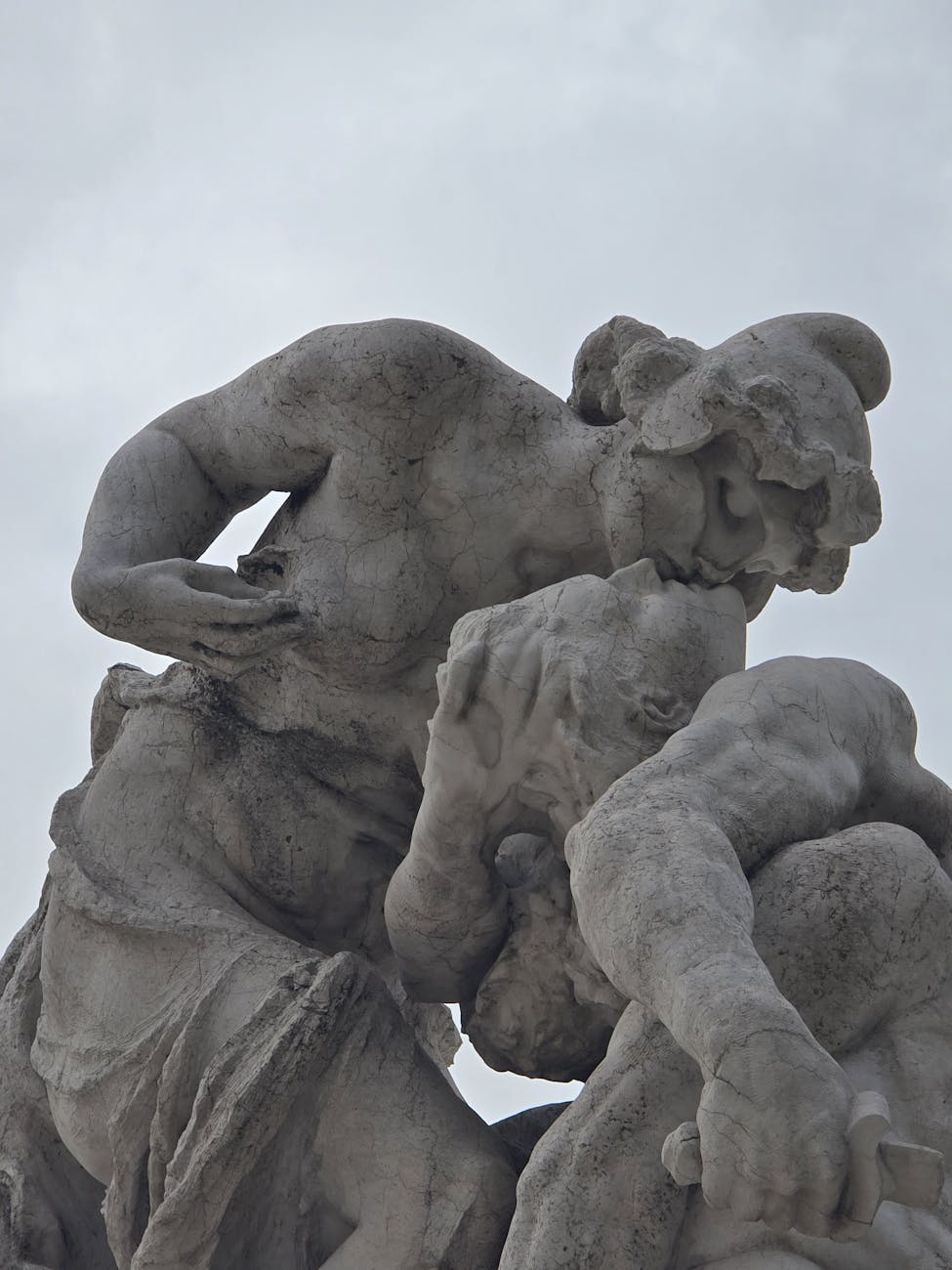 dramatic stone sculpture of figures embracing